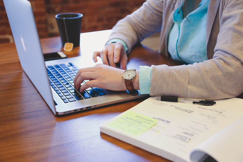 person working on laptop and workbook