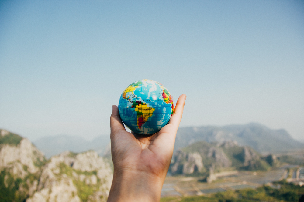 hand lifting a small globe