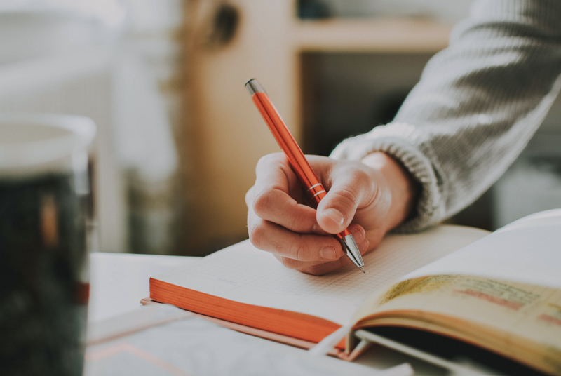 https://www.txhes.com/_resources/images/newsroom-resources/stock-photos/person-holding-orange-pen-1925536.jpg