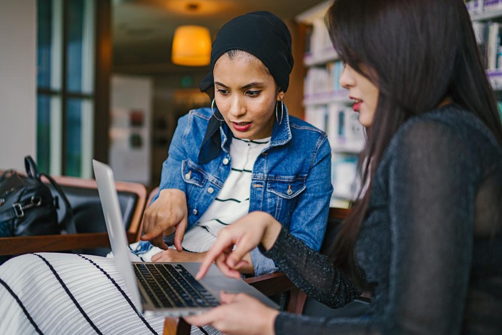 women pointing at computer