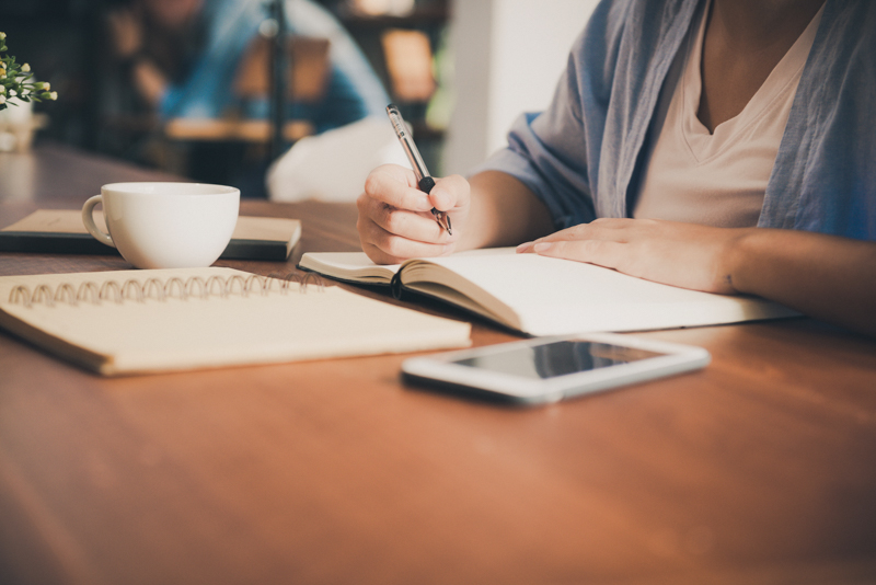 Woman writing in notebook.